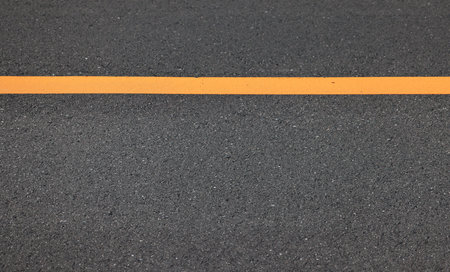 Asphalt road texture with yellow line, closeup of photo.の写真素材