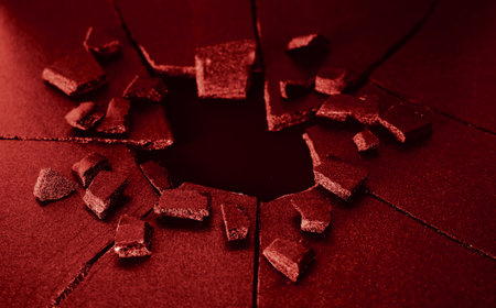 Broken glass hole in a red wall. Shallow depth of fieldの写真素材