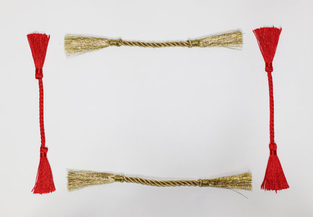 Frame made of red and gold tassels on a white backgroundの写真素材