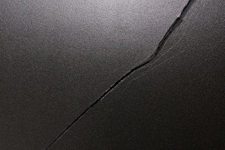 Cracks on the black ground as an abstract background. Texture.の写真素材