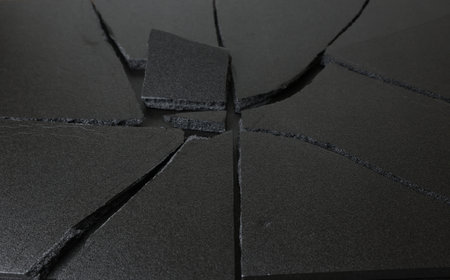 Pieces of black broken tiles on the floor. Abstract background.の写真素材