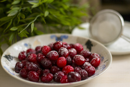 red cranberries in powdered sugar on a plateの写真素材
