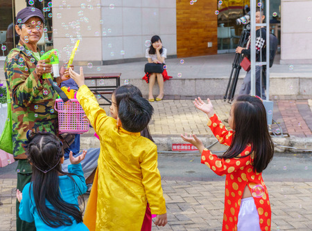 Old man, kids playing with bubble wandのeditorial素材