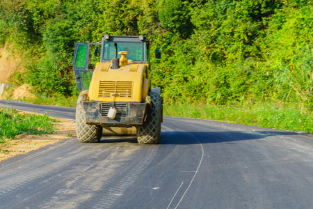 Yellow bulldozer on the road