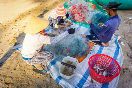 These people harvesting fishing on fishnet in Ke Ga beachのeditorial素材