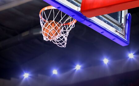 Basketball shot to the hoop with bright spotlights background