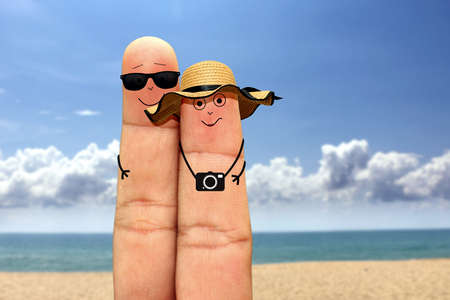 Happy finger couple face on vacation at the beachの写真素材