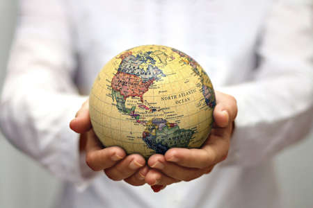 women holding world map globe on her handの写真素材