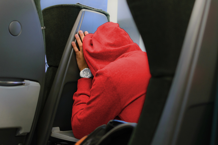 Someone with a hoodie sleeping while travelingの写真素材