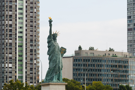 Statue of liberty in Paris, France with tall building in the backgroundの写真素材