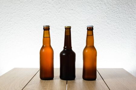 Cold beer bottle without label on wooden table back-lit isolated on white backgroundの写真素材