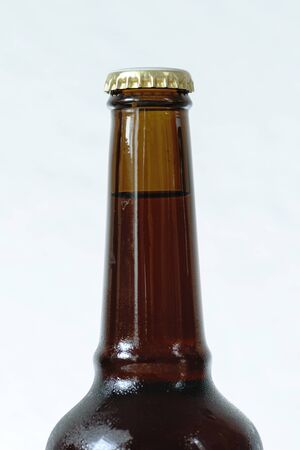 Cold beer bottle without label on wooden table back-lit isolated on white backgroundの写真素材