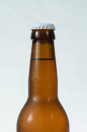 Cold beer bottle without label on wooden table back-lit isolated on white backgroundの写真素材