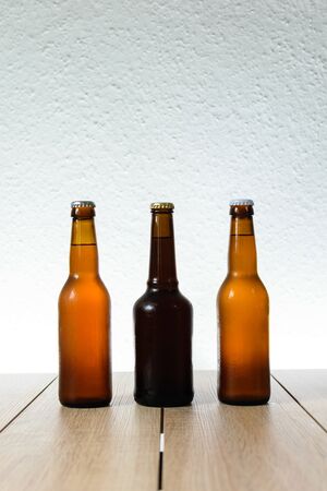 Cold beer bottle without label on wooden table back-lit isolated on white backgroundの写真素材