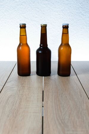 Cold beer bottle without label on wooden table back-lit isolated on white backgroundの写真素材