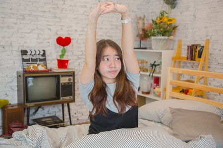 Young beautiful asian woman just wake up in the morning, Beautiful young asian girl are stretching themselves in bed, lazy girlの写真素材