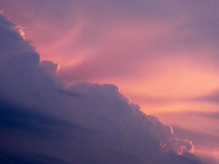 Purple orange shades of sky with large cloud details and interesting evening atmospheric moodの写真素材