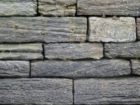 Aged gray dark wall made of textured bricks shot full lengthの写真素材