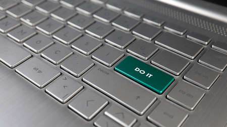 Close-up of a laptop keyboard with a green button with the word do it