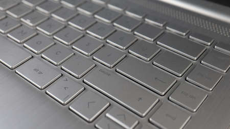 Close-up of silver metallic laptop keyboard. Technology concept. Selective focus.