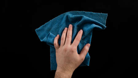 Cleaning table with blue cleaning cloth, male hand clean desk, isolated on black background, top viewの写真素材