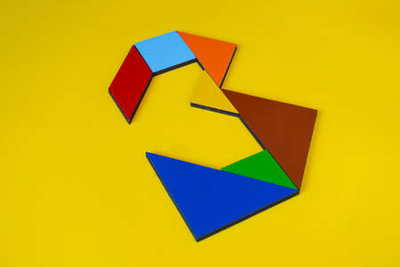 Colorful wooden puzzle on a yellow background. The concept of logical thinking.の写真素材