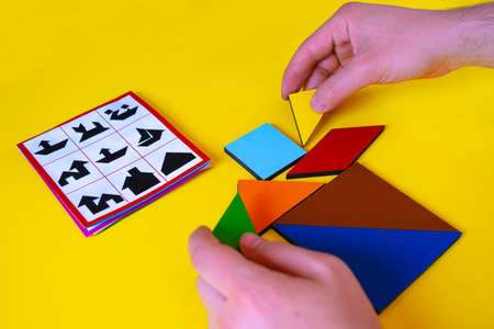 Wooden puzzle game for children on a yellow background. The development of logical thinking.