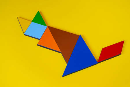 Colorful paper tangram on a yellow backgroundの写真素材