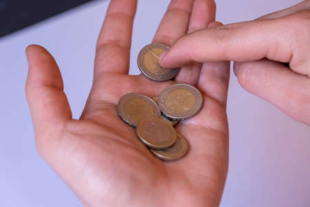 Hand with coins on a white background. The concept of saving money.の写真素材