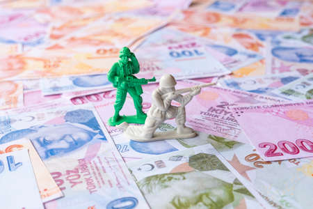 Toy soldiers on the background of a large amount of money