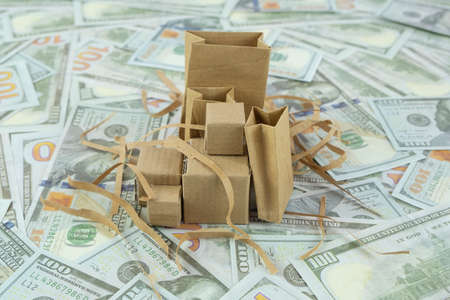 Conceptual image of cardboard boxes on the background of dollar billsの写真素材