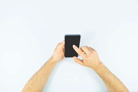 Male hands holding smartphone with blank screen on white background. Mock up