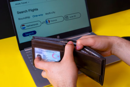 Man holding a credit card and using a laptop for online shopping.