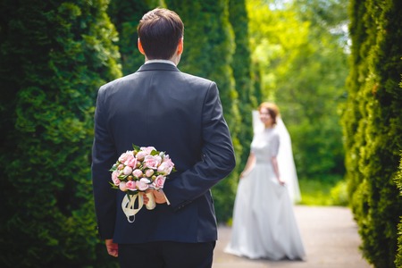Beautiful bouquet of fresh flowers in hands of Bridegroomeの写真素材