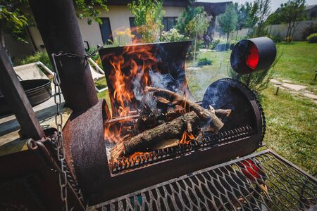 firewood for meat inflame in an iron oven train charcoal grill barbecue. barbecue preparation. fire for meat. Fire under barbeque grill closeup. flames is ready for cooking. photo for firewood storeの写真素材