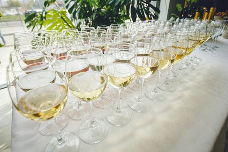 A lot of glasses of champagne in a luxurious atmosphere. Stylish, toned photo. Secular reception, new year, wedding. champagne glasses arranged lined in a long rowの写真素材