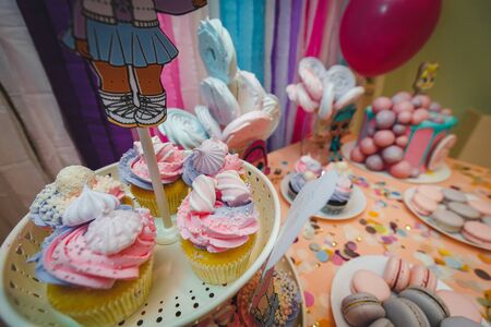 Beautifully decorated catering banquet table with candy Bar with cocktails and sweet unicorn cake pie. colorful macaron biscuits. Photo of coffee break or kids birthday pink styleの写真素材
