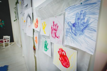 childs drawing. Colorful hand drawing print of hands isolated on white wall background. Childrens handprints on school kindergarten wall. educational img photo for school or kindergartenの写真素材