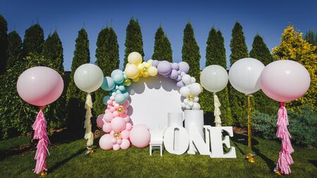 Photo zone in pink white style with paper stars, balloons, large, voluminous paper figure word one. birthday decor. Holiday decoration.Balloons. Children party backgroundの写真素材