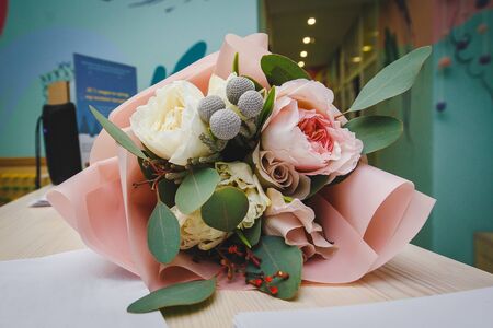 beautiful wedding bouquet with white and pink roses and other colorful flowers lying on the table close-up.の写真素材