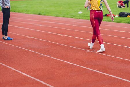 Young fitness woman in white shoes and red leggings walking on running court or treadmill. Woman wear sport shoe on to run in running court background. Health exercise life styleの写真素材