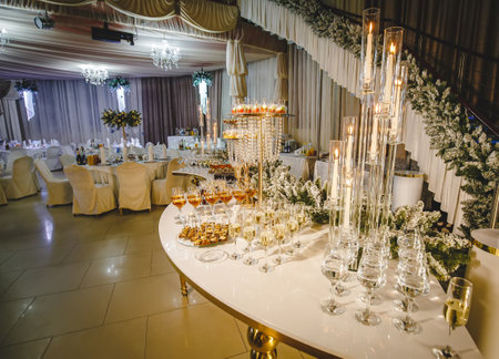long luxury sumptuous decorated banquet table. high floating candles, crystal and gold ,champagne in glasses flute, appetizer and cold cutsの写真素材