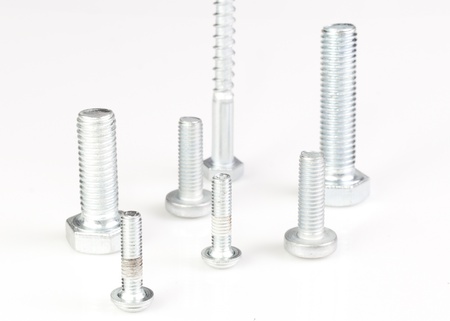Seven silver metal screws isolated on white background 