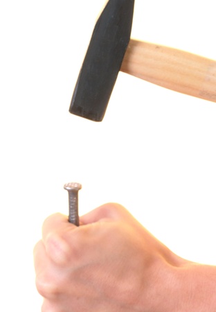 Hammering a nail into wooden plank の写真素材