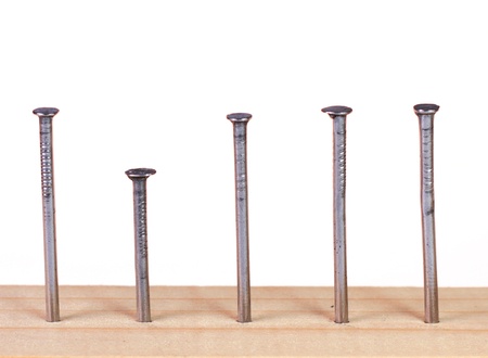 Different height nails in wooden plank の写真素材