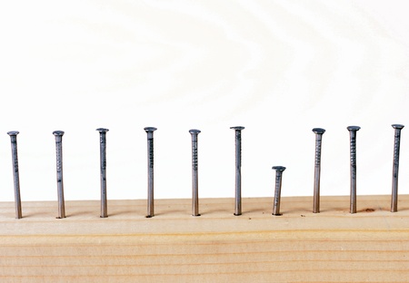 Different height nails in wooden plank の写真素材