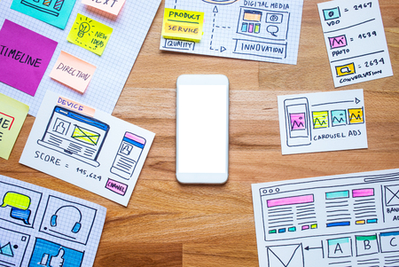 Business digital marketing with smartphone and paperwork sketch on wood table.analysis strategy...