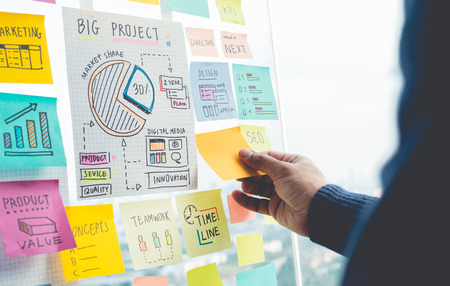 Sharing ideas concepts with papernote writing strategy on wall glass office.Business marketing and communicationの写真素材