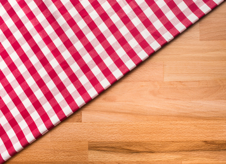 Red checkered fabric on wood table background.For decoration key visual layoutの写真素材