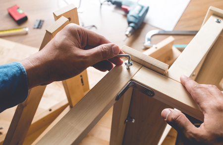 Man assembly wooden furniture,fixing or repairing house with screwdriver tool.modern living concepts ideasの写真素材